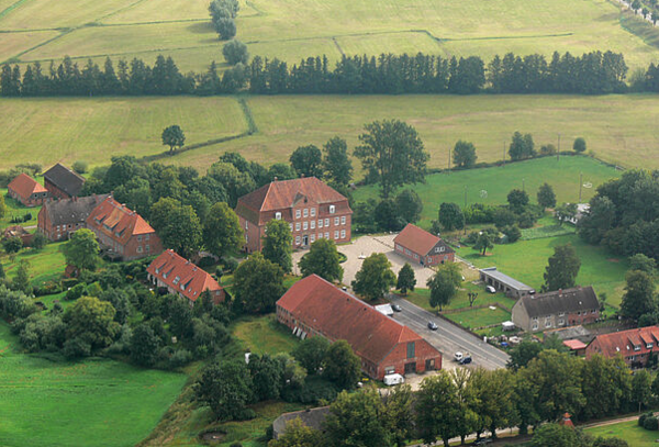 Ein Bild aus der Luft. Zu sehen ist ein Schloss und seine Nebengebäude.