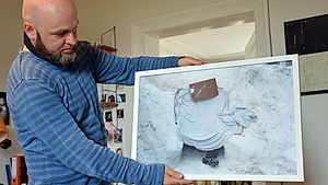 Heiko Krause hält eines seiner Bilder in den Händen.