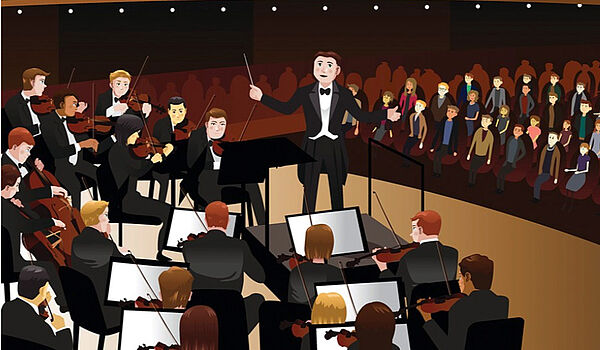 Eine Bühne. Auf der Bühne sitzen Musiker. Vor der Bühne sind Zuschauer.