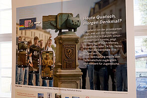 Eine Katze als Kunstfigur. Sie steht auf einem Podest.