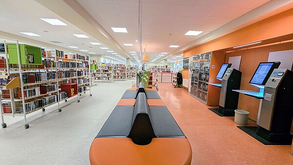 Blick in eine Bibliothek. Links stehen Regal mit Büchern.