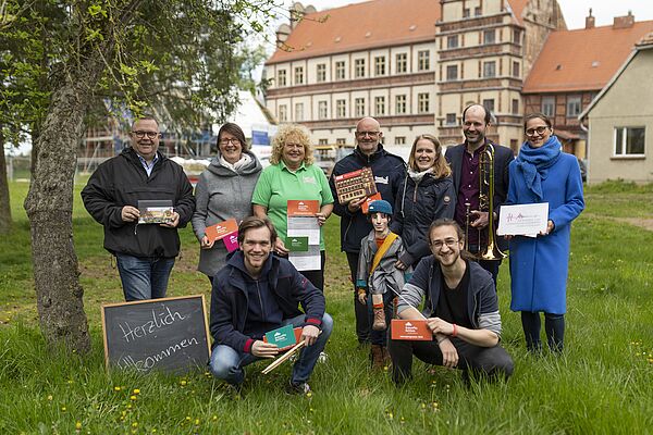 Neun Leute stehen vor dem Schloss in Gadebusch und präsentieren das Programm für 2023.