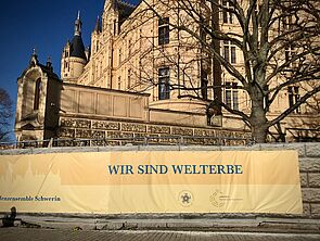Ein Banner hängt am Schweriner Schloss.