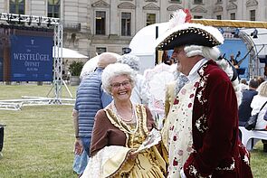 Ein Mann und eine Frau sind verkleidet. Sie lachen.