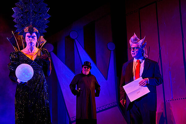 Drei Schauspieler stehen auf einer Bühne.