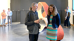 Bettina Martin unterhält sich in einem Ausstellungsraum mit Broder Burow.