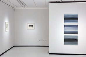 Blick in den Ausstellungsraum. An der Wand hängen Bilder.