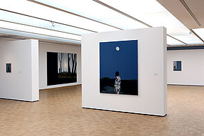 Auf dem Bild vorn schaut eine Frau in die Nacht. Der Mond scheint.