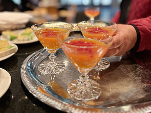 Orangefarbene Cocktails auf einem Tablett.