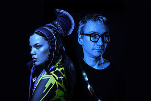 Ein Mann und eine Frau. Sie sind in blaues Licht gehüllt. 