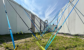 Zwei Zelte. Viele Seile halten die Zelte. Sie sind im Boden verankert. 