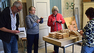 Vier Leute stöbern in der Kunst von Rolf Wicker.