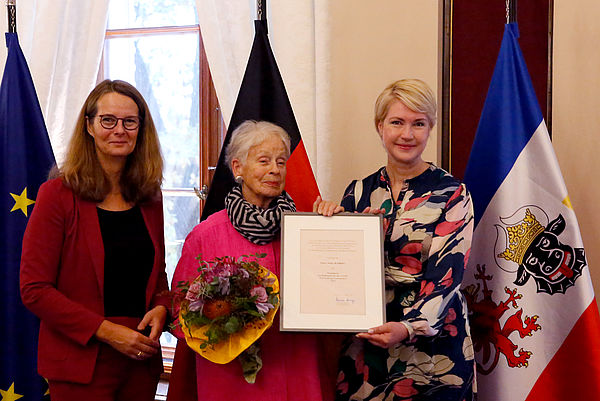 Anka Kröhnke erhält Urkunde und Blumen. Umrahmt wird sie von Kulturministerin und Ministerpräsidentin.
