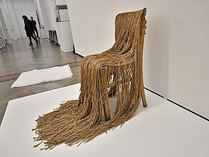 Ein Stuhl ist mit vielen dicken Fäden bedeckt.