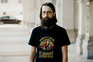 Ein Mann steht in einer Straße vor einem Gebäude.