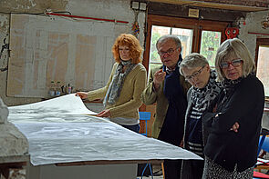 Die Kunstkommission blättert in großen Zeichnungen von Michael Mohns.