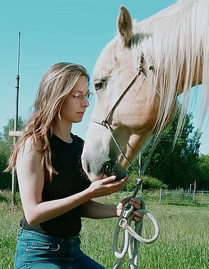 Ein Mädchen und ein Pferdekopf.