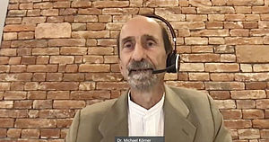 Porträt von Dr. Michael Körner aus der digitalen Gesprächsrunde. Er trägt ein Headset.