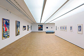 Blick in die Ausstellung. An drei Wänden hängen Bilder.