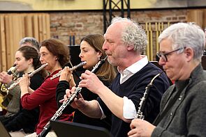 Sechs Musiker spielen Flöte und Klarinette.