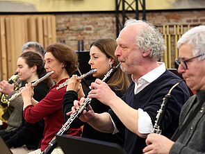Sechs Musiker spielen Flöte und Klarinette.