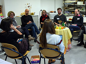 Vier Frauen und drei Männer sitzen sich in einem der Workshops im Kreis gegenüber und unterhalten sich. 