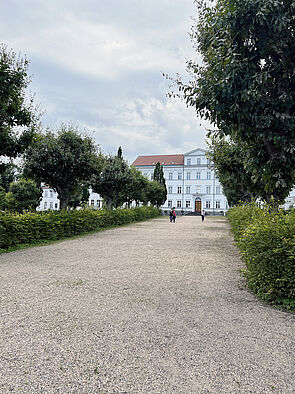 Ein Weg mit einem weißen Gebäude im Hintergrund