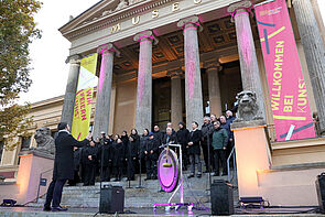 Musiker singen auf der Treppe vor dem Museum.