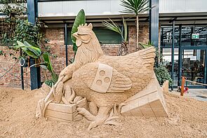 Ein Huhn aus Sand gebaut.