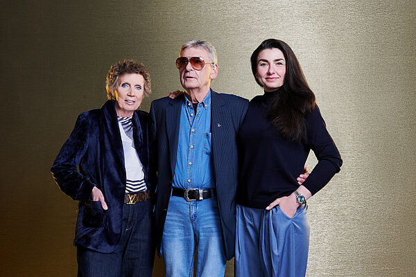 Drei Personen stehen nebeneinander: eine Frau, ein Mann und eine Frau. 