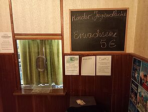 Der Kassenbereich des Kinos. Auf einer Tafel stehen die Eintrittspreise.