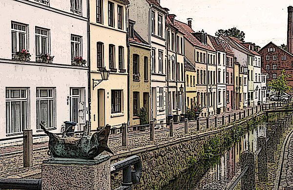 Eine Straße in Wismar. Mehrere zwei- und dreistöckige Häuser reihen sich aneinander. Vor den Häusern führt eine schmale Kopfsteinpflasterstraße entlang. Daneben fließt ein Kanal. Im Vordergrund liegt eine Bronzefigur auf einem Sockel. Das Foto sieht aus wie eine Zeichnung.