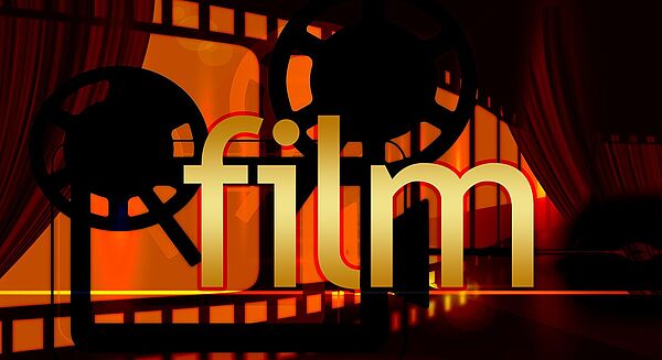 Vor einem roten Hintergrund befinden sich ein schwarzer Filmstreifen und ein Filmrolle. Im Vordergrund steht in goldenen Buchstaben das Wort "Film".