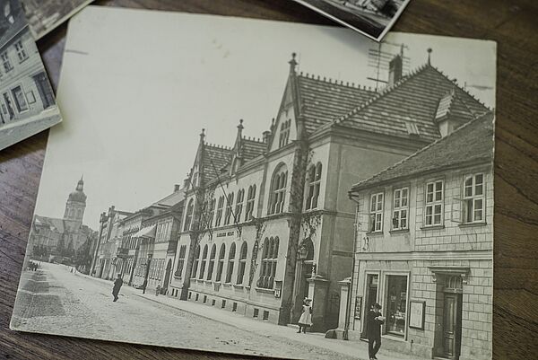 Eine alte Postkarte. Zu sehen sind Häuser in Schwarz-Weiß.