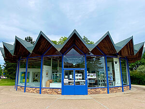 Ein runder Glasbau. Das Dach liegt in Falten, die über den Fenstern spitz zu laufen.