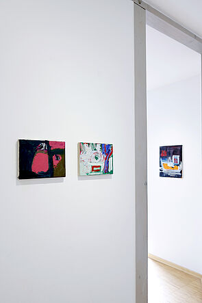 Blick in die Ausstellung. Drei Bilder hängen an der weißen Wand.