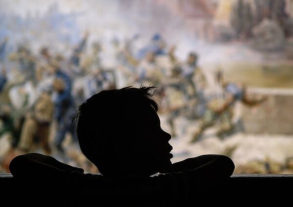 Ein Kind steht vor einem Gemälde.