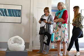 Mitglieder der Kunstkommission betrachten Skulpturen.