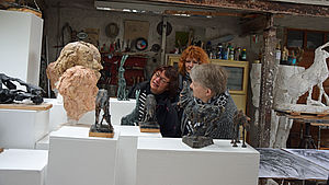 Drei Mitglieder der Kunstkommission betrachten Büsten und Skulpturen.