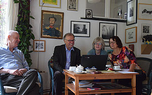 Oskar Manigk sitzt mit einem Mann und zwei Frauen von der Kunstkommission am Kaffeetisch. 