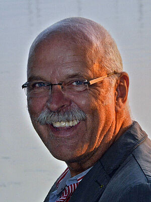 Susanne Gilbert und Uwe Driest stehen Rücken an Rücken in einem Raum. 