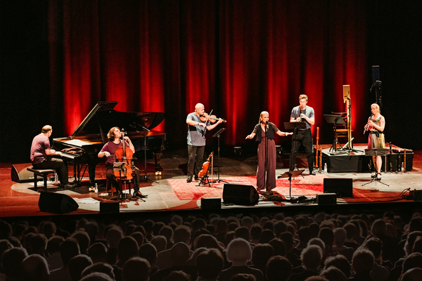 Musiker spielen Instrumente auf einer Bühne.