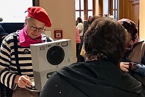 Ein Mann zeichnet Porträts von Gästen.