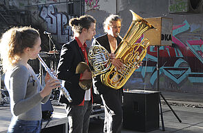 Drei Musikerinnen und Musiker bei ihrem Spiel.