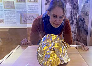 Archäologin Dr. Katja Winger schaut in die Vitrine mit der nachgebildete „Maske des Agamemnon“.