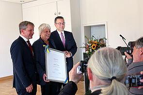 Drei Männer werden fotografiert.