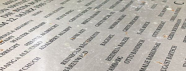 Auf einer Gedenktafel stehen Namen über Namen.