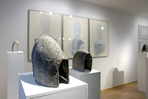 Kunstobjekt sind ausgestellt. An der Wand hängen Bilder.