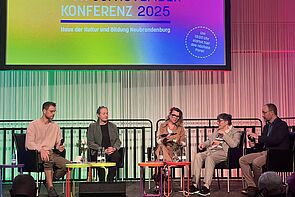 Blick auf die Bühne. Fünf Menschen diskutieren über Kultur.