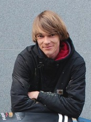 Daniel Wrede Daniel Wrede steht draußen, hinter einem Modell-Löwen und stützt sich auf dessen Rücken.